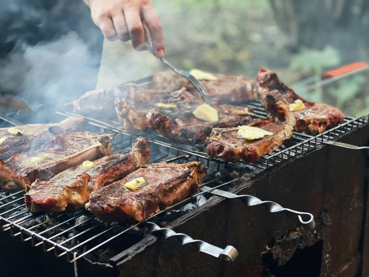 a grill with steaks on it is being grilled