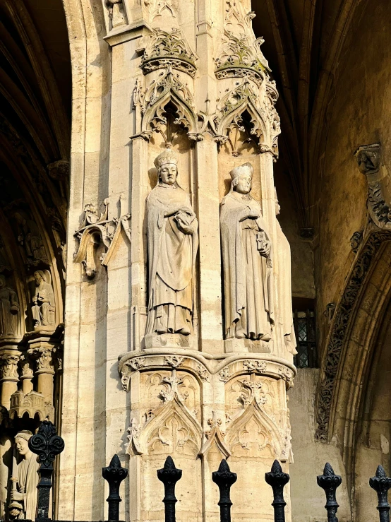 several sculptures on a pillar in a cathedral