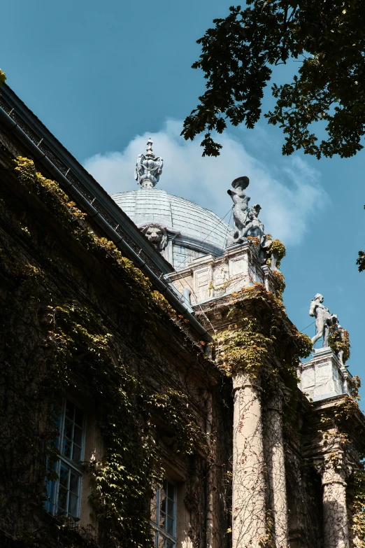 an ornate building with statues and ivy on the sides