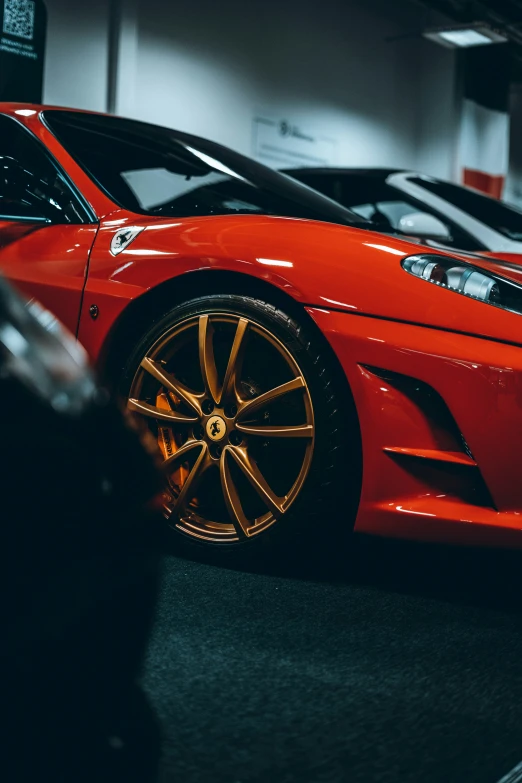 an orange sports car parked in front of other cars