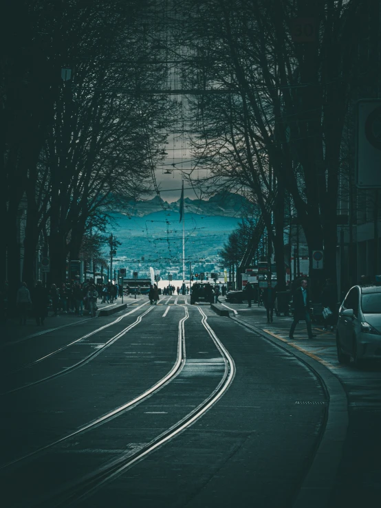 a dark city street filled with cars driving on the road