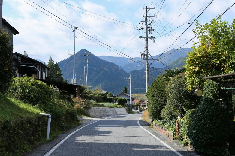 a road in the mountains with telephone poles above