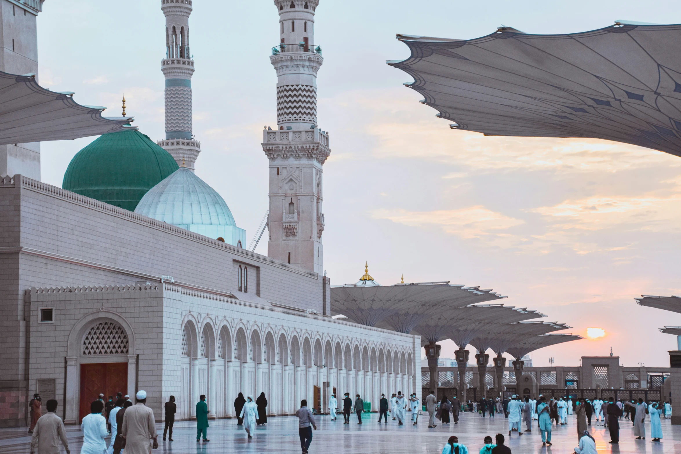 people are walking around outside of an islamic mosque