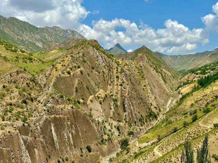 an area with mountains that are surrounded by grass