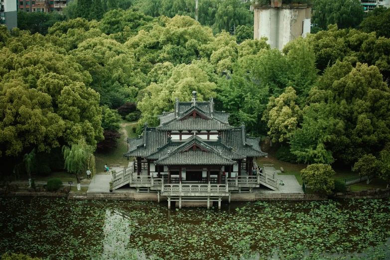 a building sitting on the water near some trees