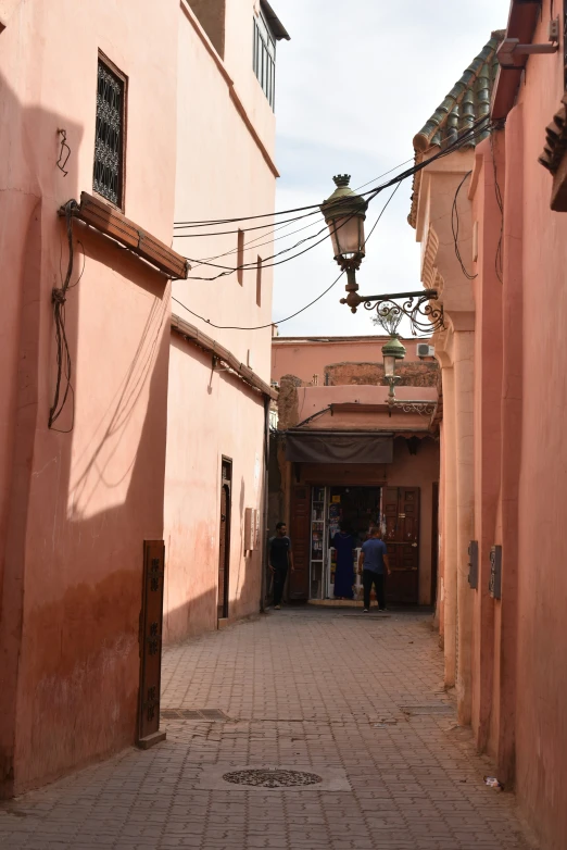 a bricked alley way between two buildings with a street light