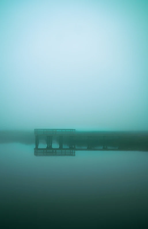 fog surrounds an empty, two - sided picnic table