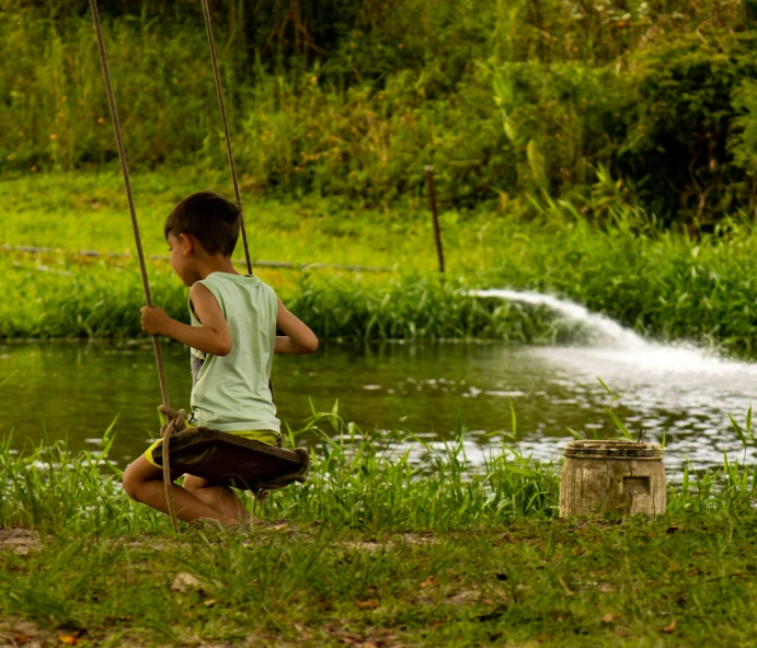 a  playing with a swing set next to a lake