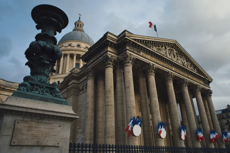 a building with multiple pillars and a large statue