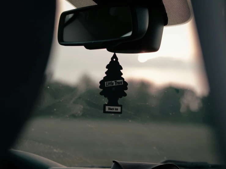 a close up view of an old car mirror with a street sign hanging from it