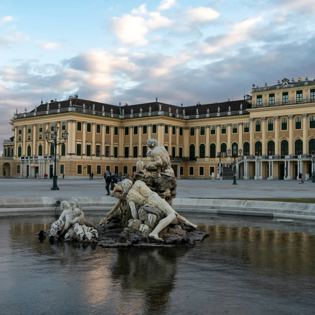 a statue on the top of a large dle in a courtyard with two people walking next to it