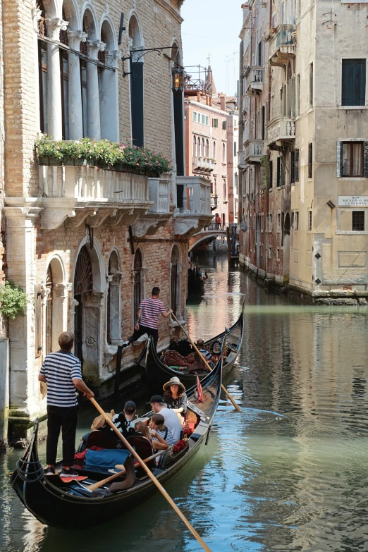 people rowing in row boats down the canals of venice