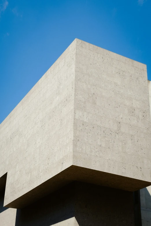 a gray building sitting under a blue sky