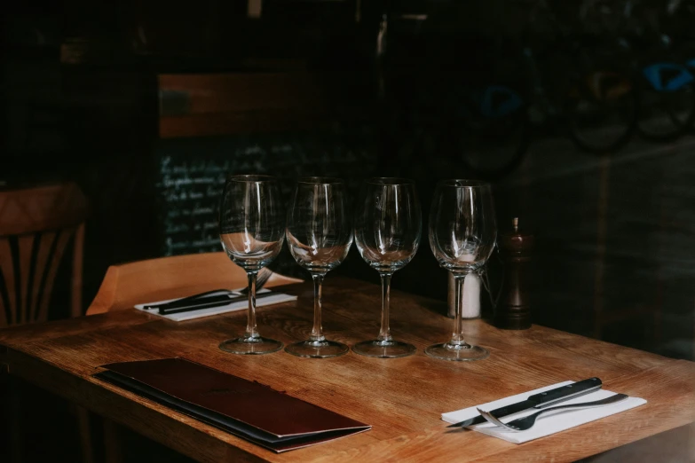 five wine glasses on a wooden table with a menu