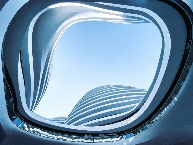 looking up at a futuristic building through a circular hole
