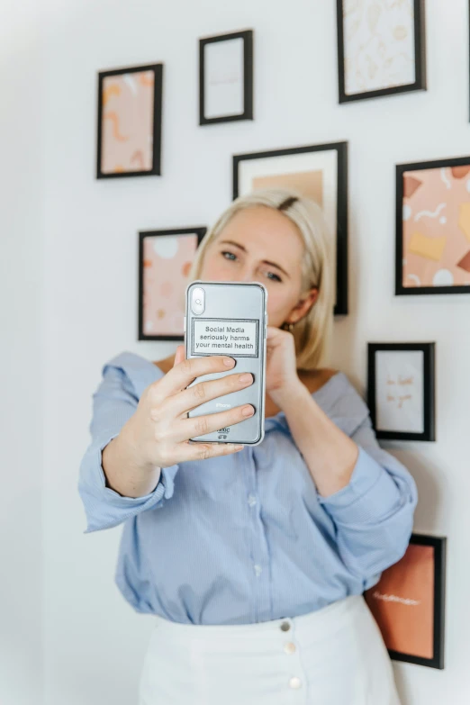 a woman taking a picture with a cellphone of her self