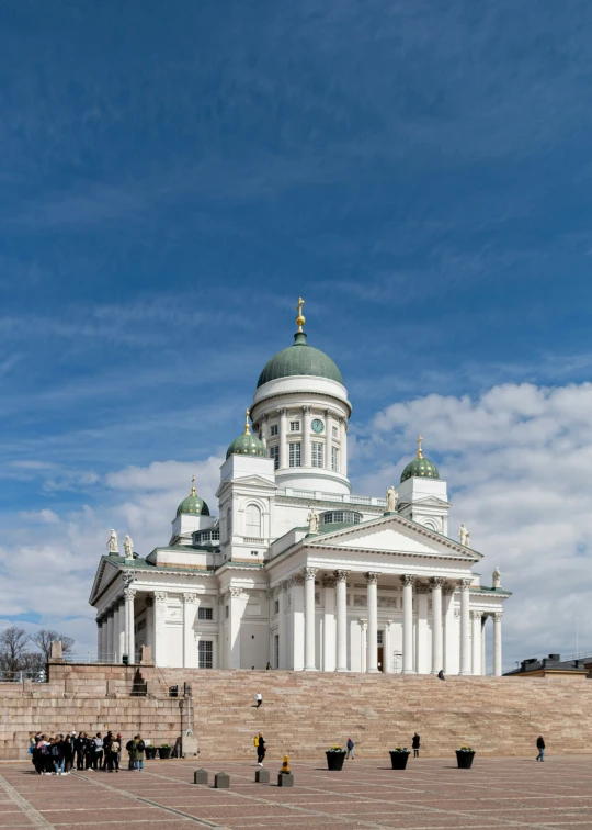 people are standing on steps in front of a white building