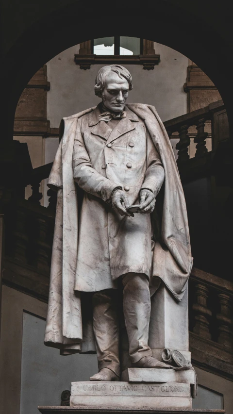 a statue of a man wearing a cloak standing up