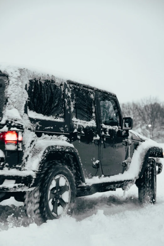 the jeep is covered in snow from a heavy blizzard