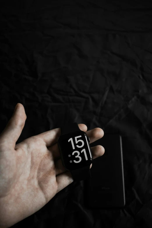 the black cube clock is held in someone's hand