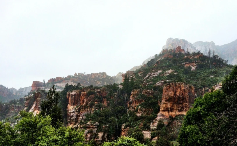 some very tall mountains with trees and some hills