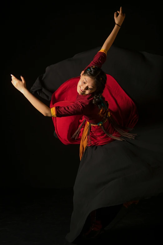 a woman wearing a red dress holds her arm out in the air