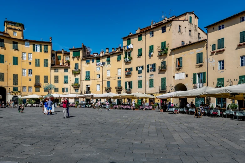 a group of people are walking in the street by buildings