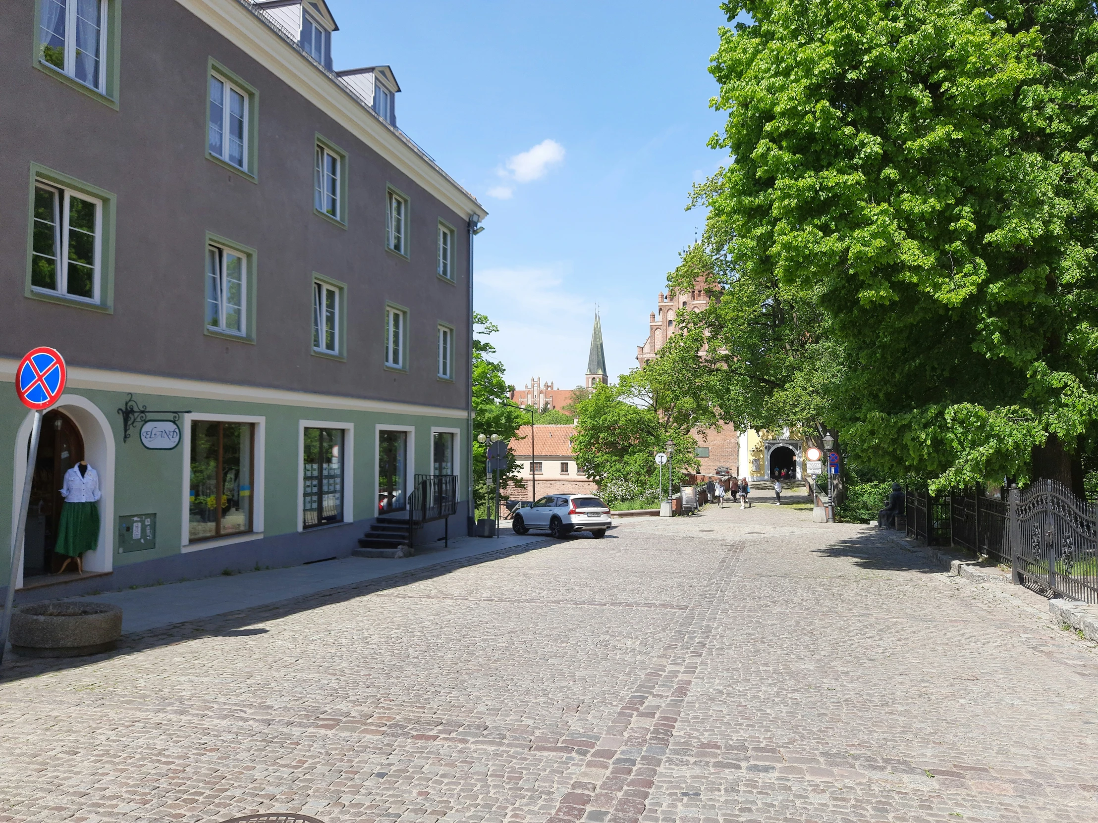 an empty street in front of two brown buildings