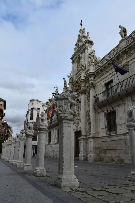 old buildings with columns surrounding them in front of the clouds