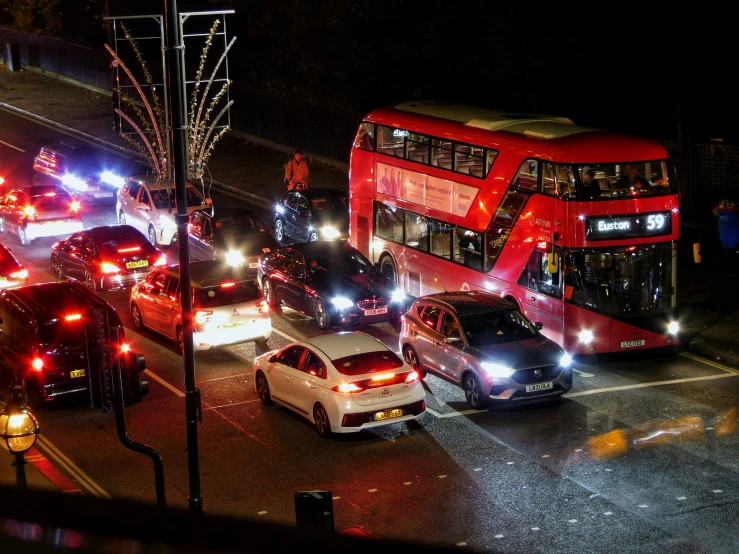 a busy intersection with double decker bus, cars and traffic lights