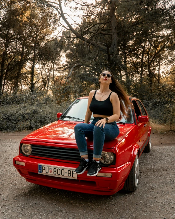 a lady sitting on the hood of her car