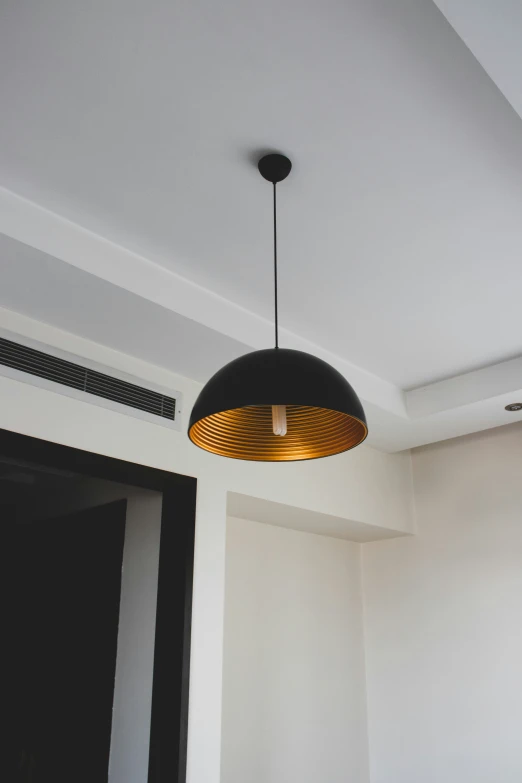 a black and gold light hangs above a living area