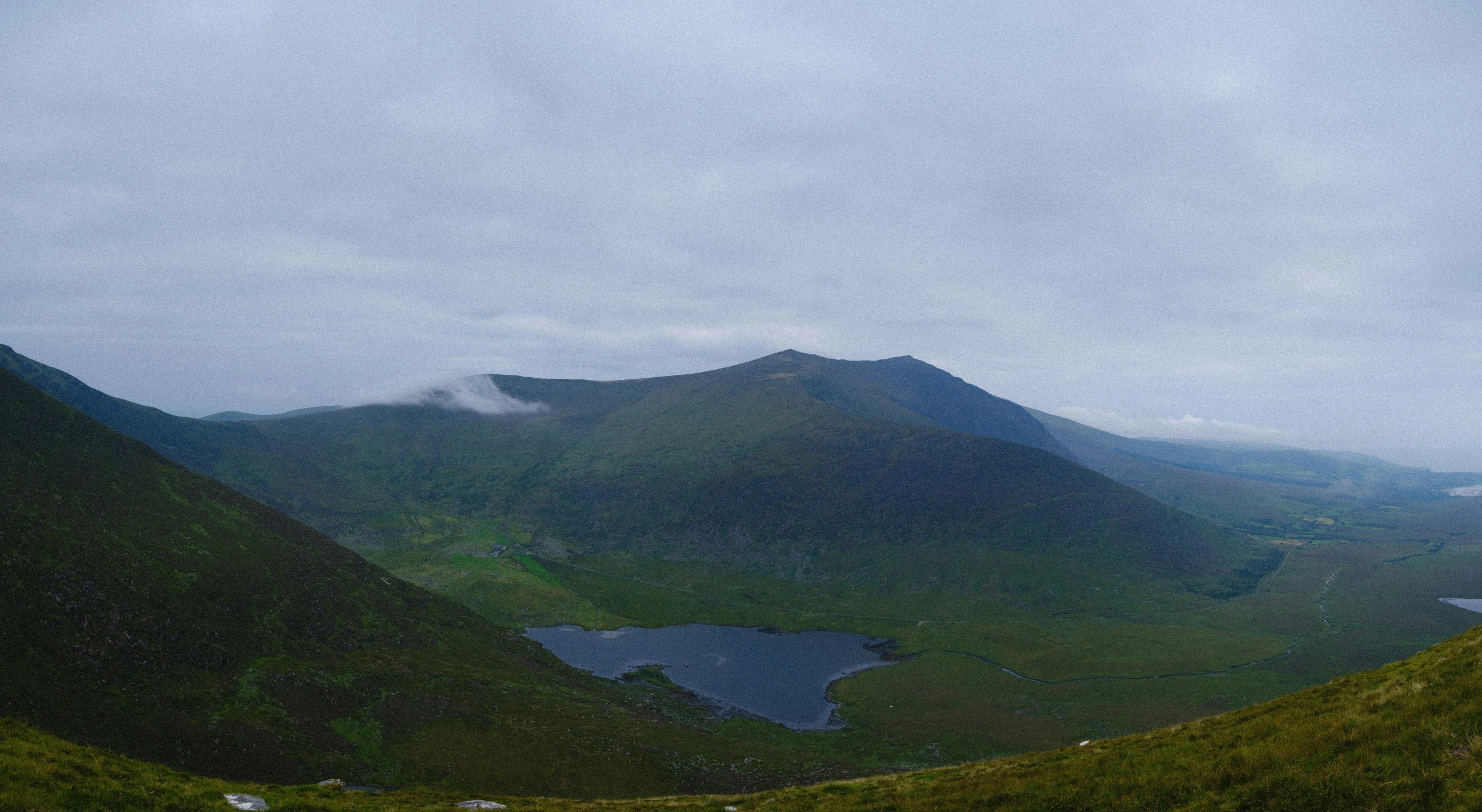 a large mountain range with a lake in the center