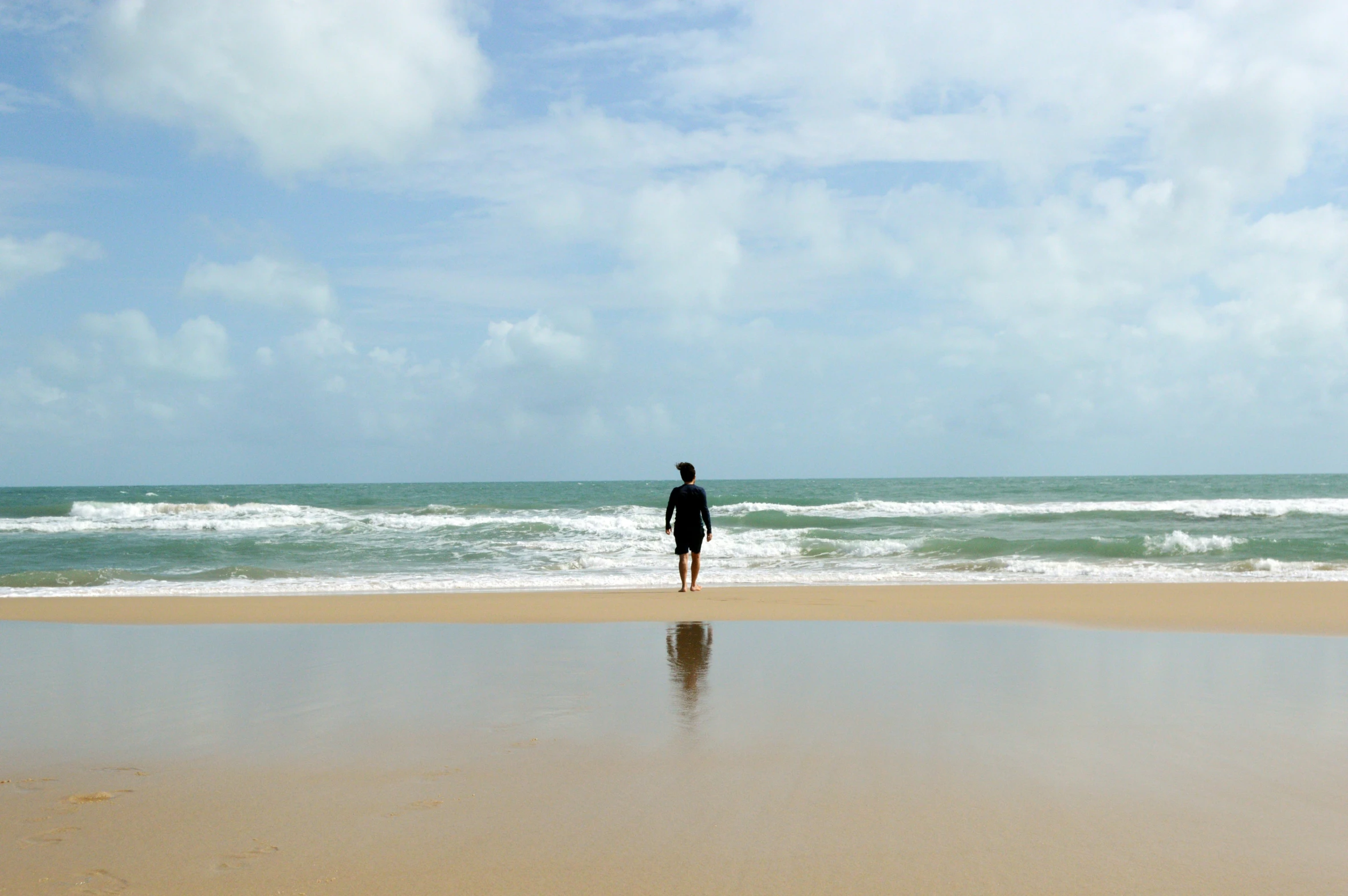 a person standing in the sand on a beach