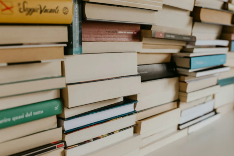 stack of books sitting on the back of a dresser