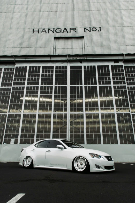 a white car in front of a large building