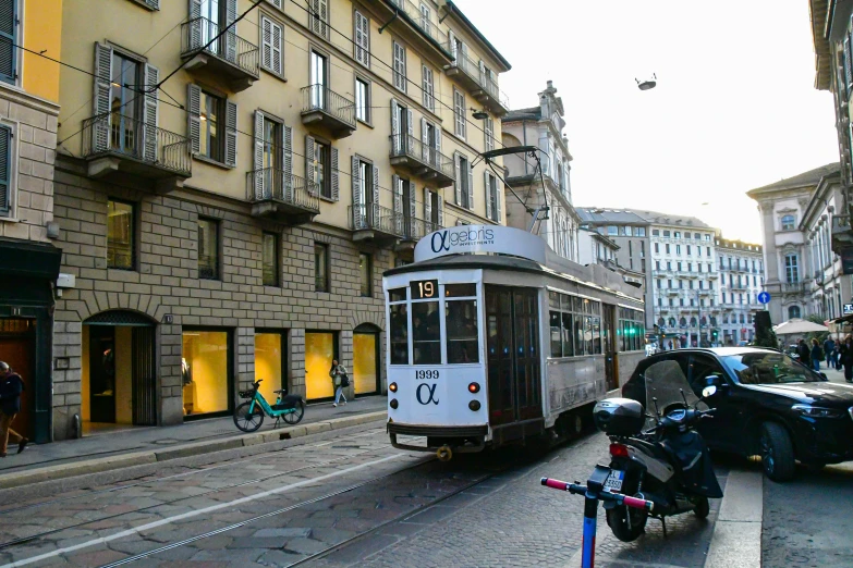 a white trolley is traveling through an old town