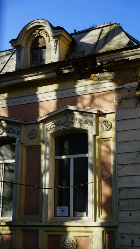 the shadow of a clock on a building has been cast by the window