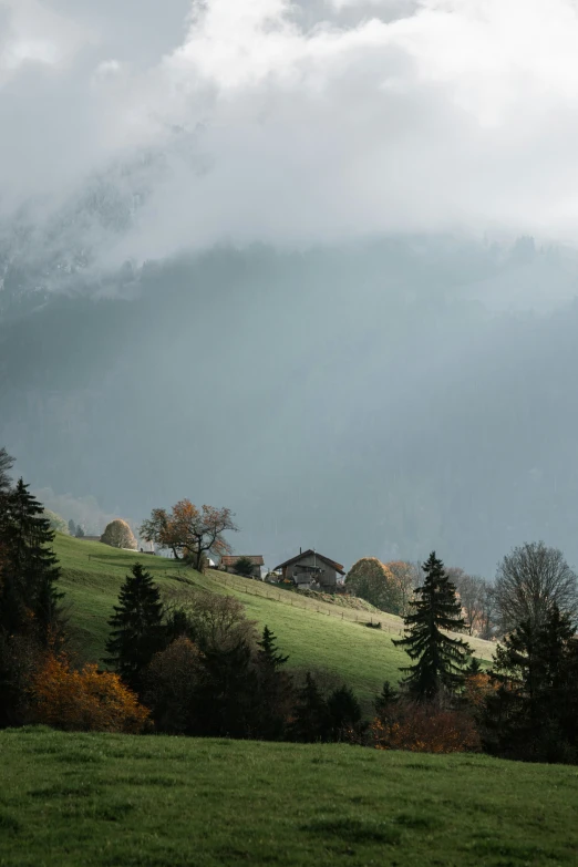 an old house sits at the top of a grassy hill