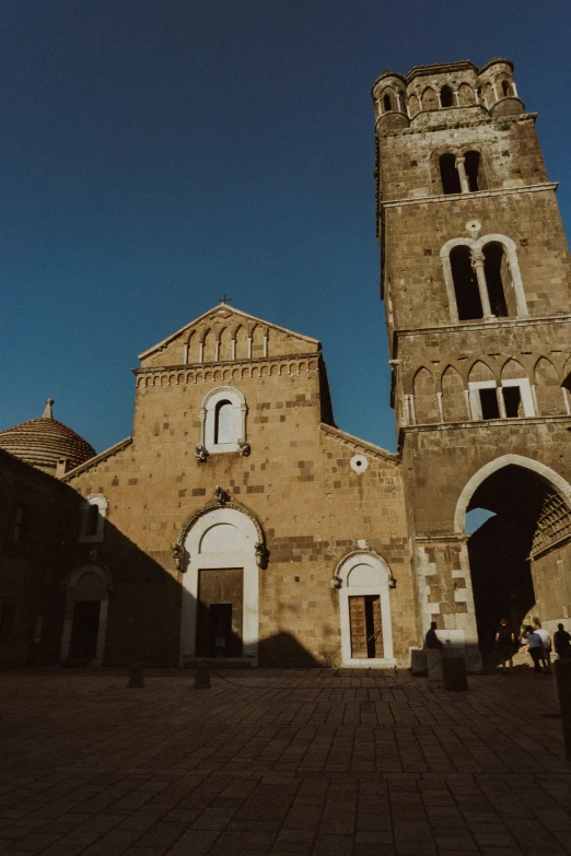 a tall building with an arched doorway and two windows