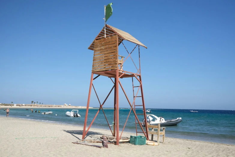 a metal and wood structure on a beach near the ocean