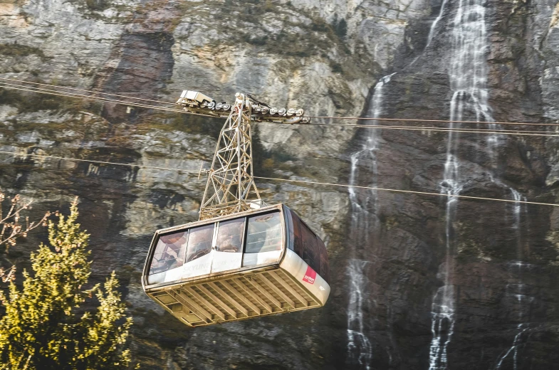 a cable car with waterfall as backdrop