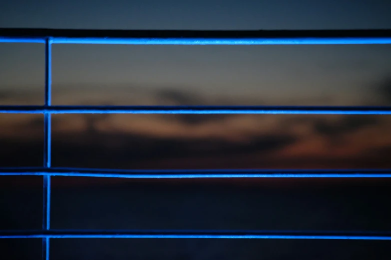 a blue window frame is showing the view at sunset