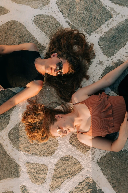 a couple of women laying on the ground next to each other