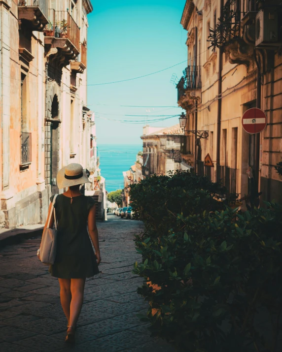 a woman walks down an alleyway with houses lining it