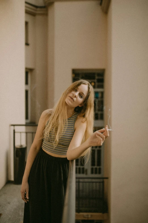a woman holding a cigarette in one hand and smoking a cigarette in the other