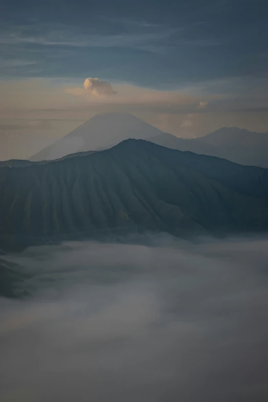 the sun is rising over the mountains with mist flowing in the valleys