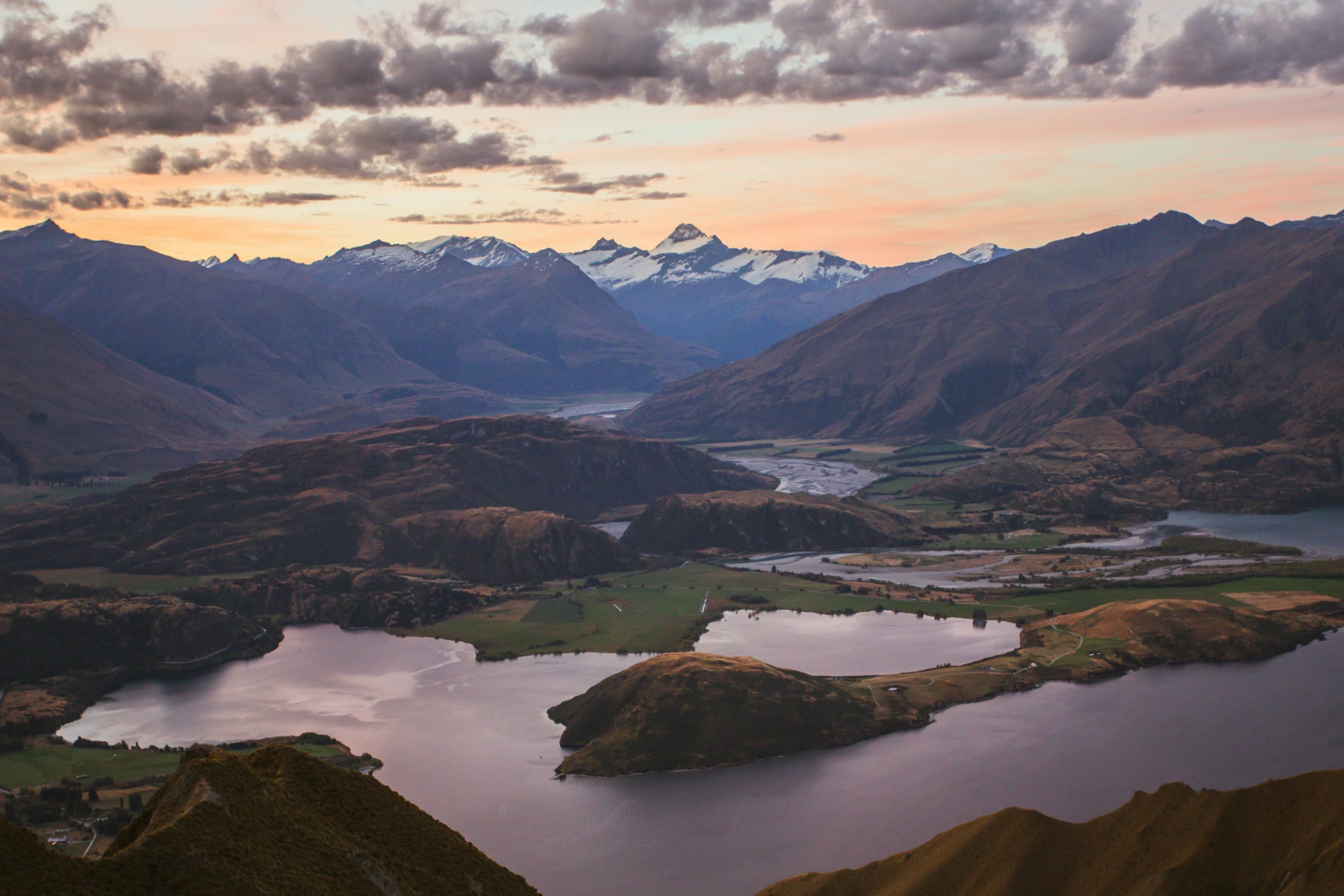 two small lakes surrounded by mountains under cloudy skies