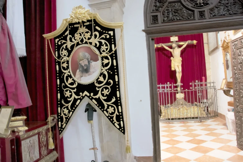 crucifix with po on side of ornate structure in public area