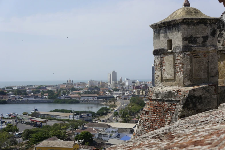 the view of a city and a body of water from a hill